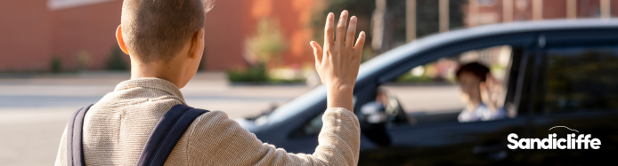 Child waving his parents at school